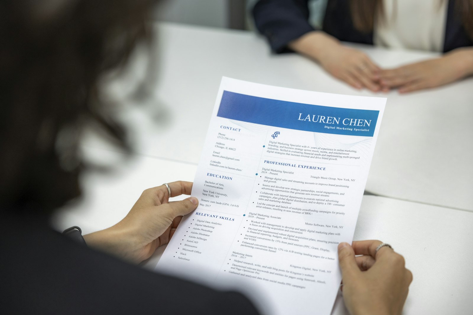Une recruteuse lit une lettre de motivation et un CV posés sur une table